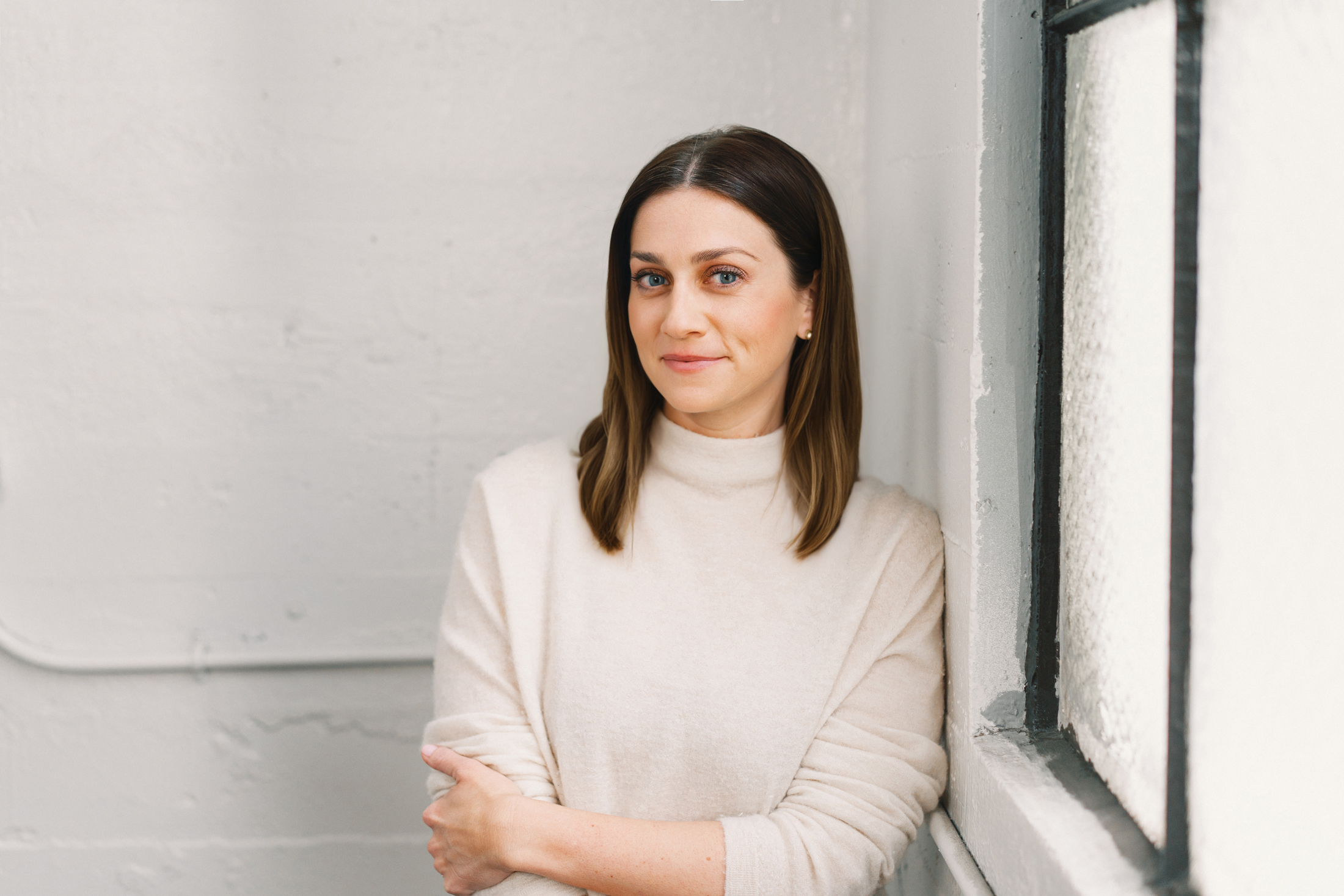 Woman with shoulder-length brown hair and cream turtleneck