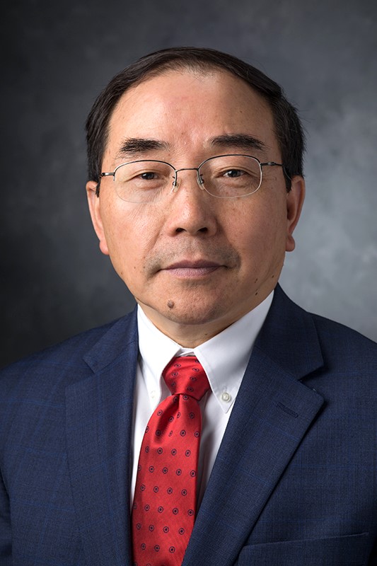 A man with glasses and a red tie and a blue blazer, Dr. S. Jack Hu