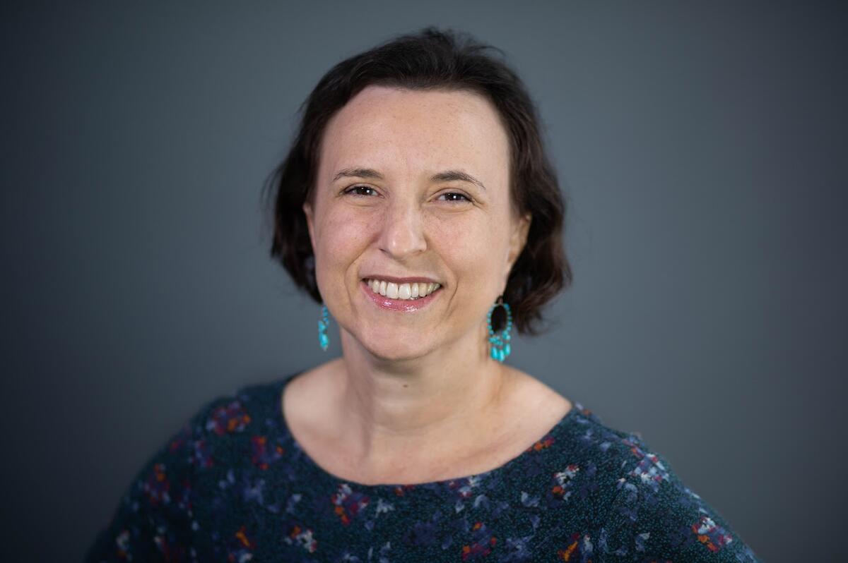 Woman with green earrings smiles