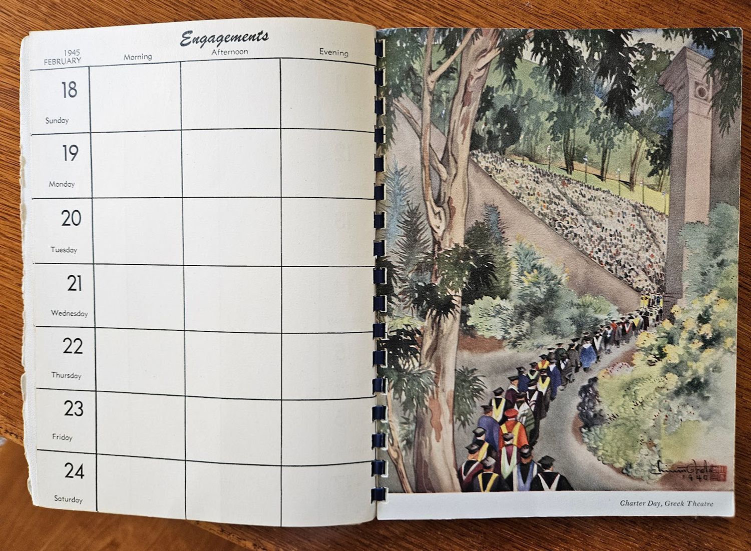 A desk calendar showing the week of February 18, 1945, with a painting by Chiura Obata of UC Berkeley students in graduation robes filing into an amphitheater