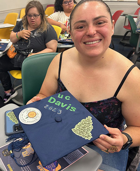 A graduating student showing off a hand-decorated mortarboard
