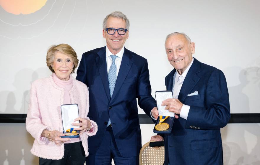 Joan Weill, left, stands next to President Milliken, who is next to Sanford I. Weill, both Weills holding their gold medals 