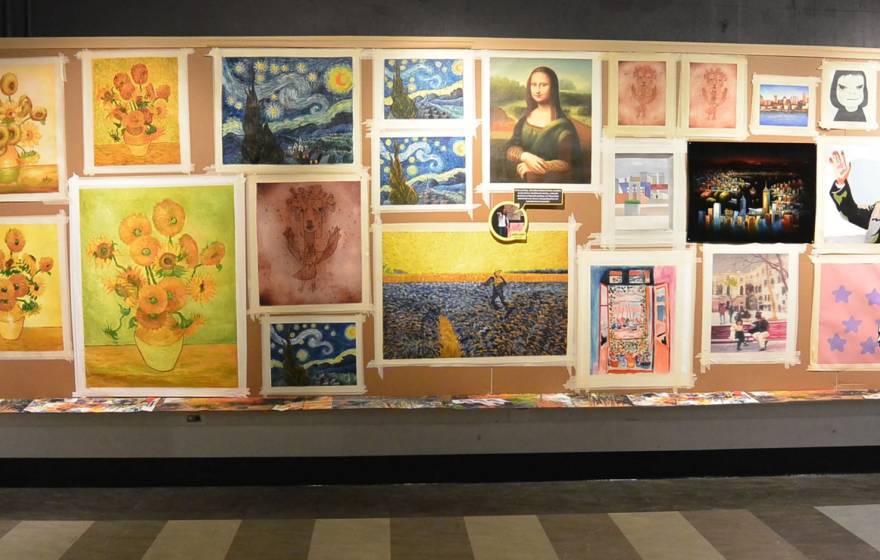 A museum gallery wall showing several versions of iconic paintings, including the Mona Lisa and Starry Night